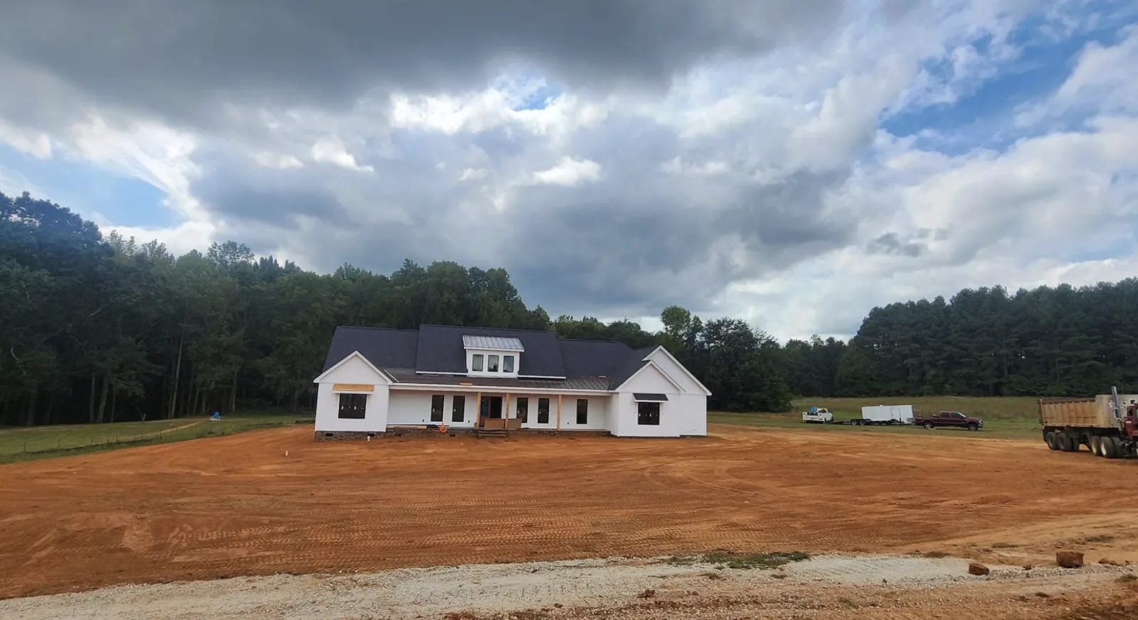 A wide lot graded flat in front of a newly built farmhouse &mdash; Little Acres Grading