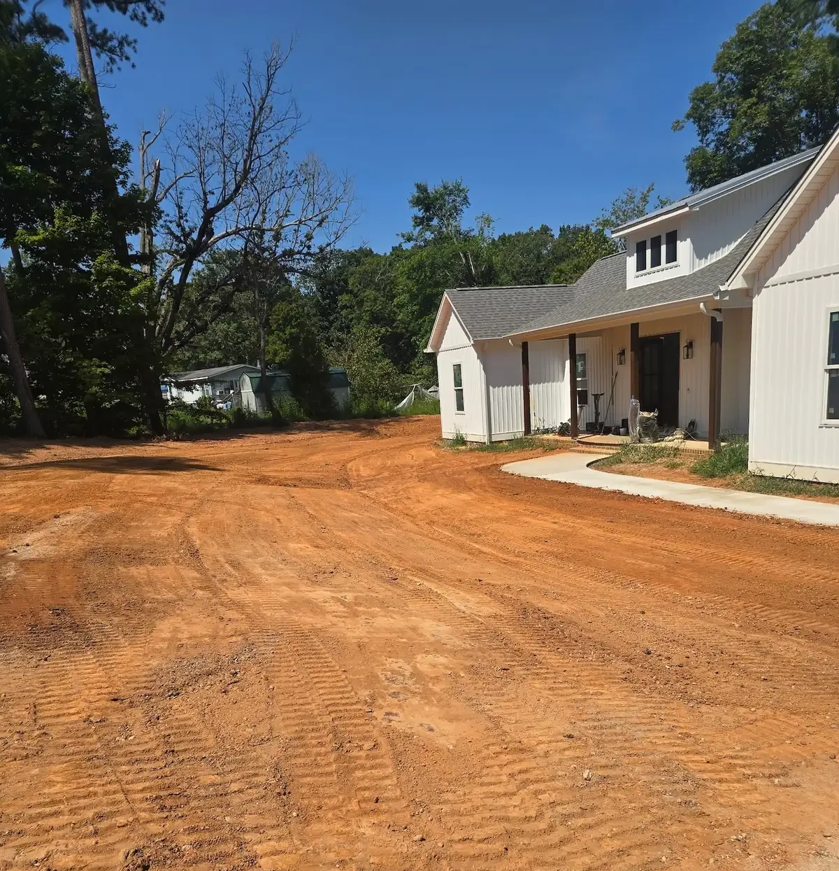 A yard cut and shaped to grade around a newly built farmhouse &mdash; Little Acres Grading
