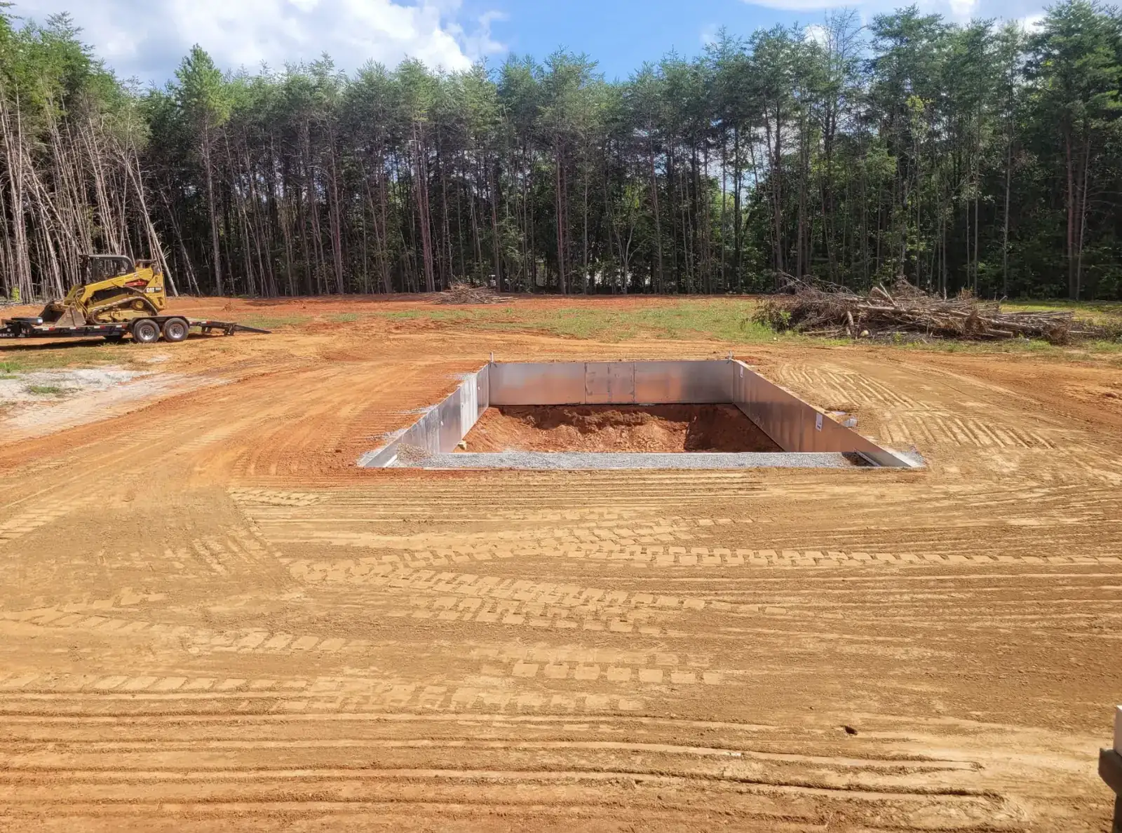 An inground pool excavated and walled in on an open cleared field &mdash; Little Acres Grading