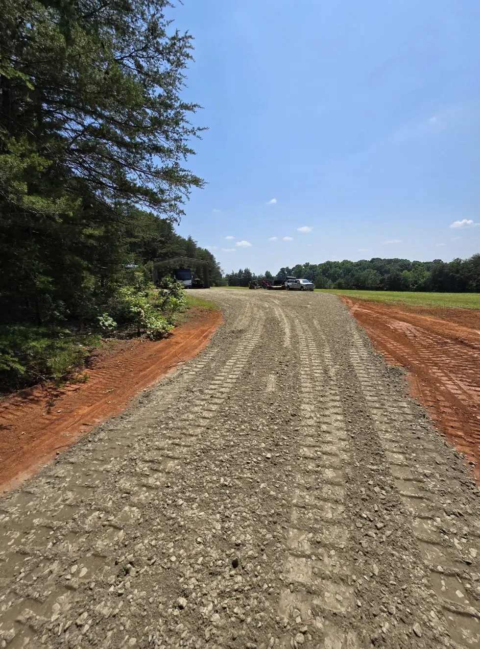 A new gravel driveway cut and stoned through a stand of pines &mdash; Little Acres Grading