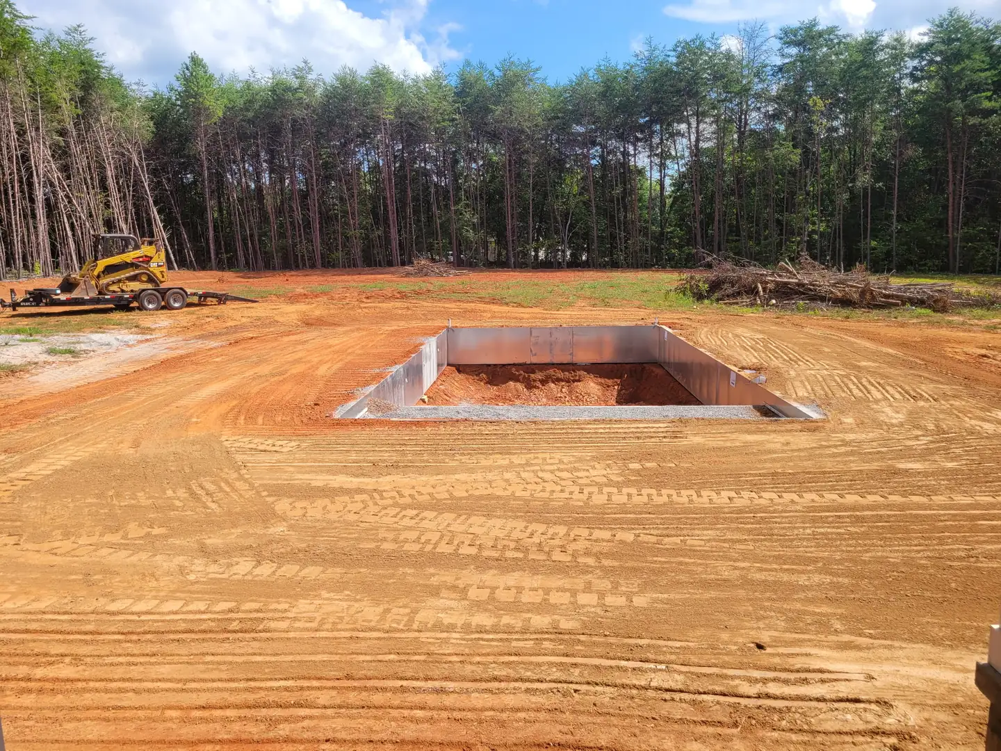 A pool excavated and shaped on a cleared field with the walls set &mdash; Little Acres Grading