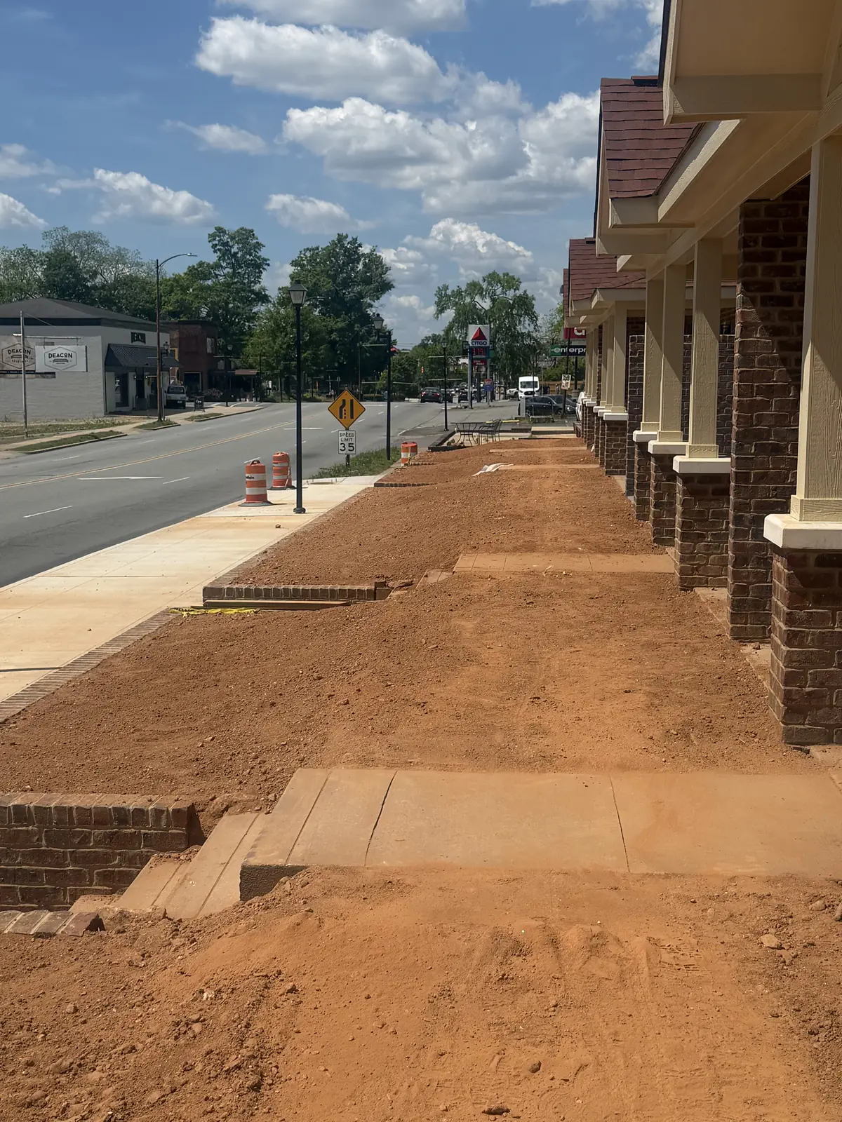 Grade work along a downtown storefront sidewalk ahead of landscaping &mdash; Little Acres Grading